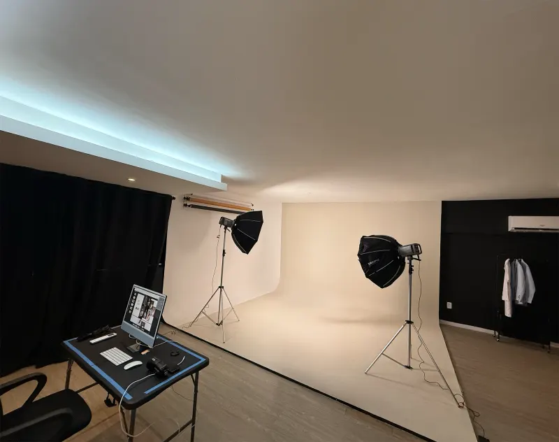 Fundo infinito branco do estúdio fotográfico em Fortaleza, com dois refletores com softbox e a mesa de apoio com computador