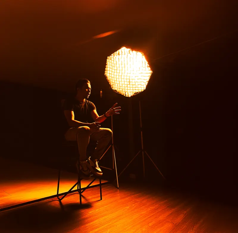 Retrato com luz laranja de octabox no estúdio escurecido